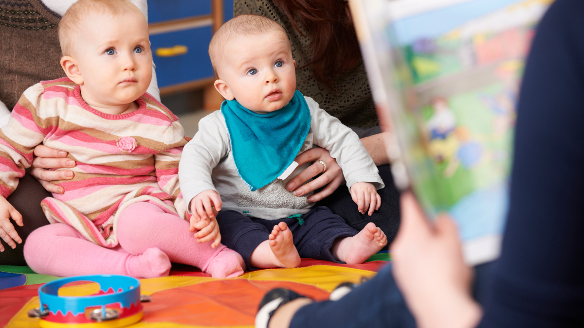 two babies being read a story
