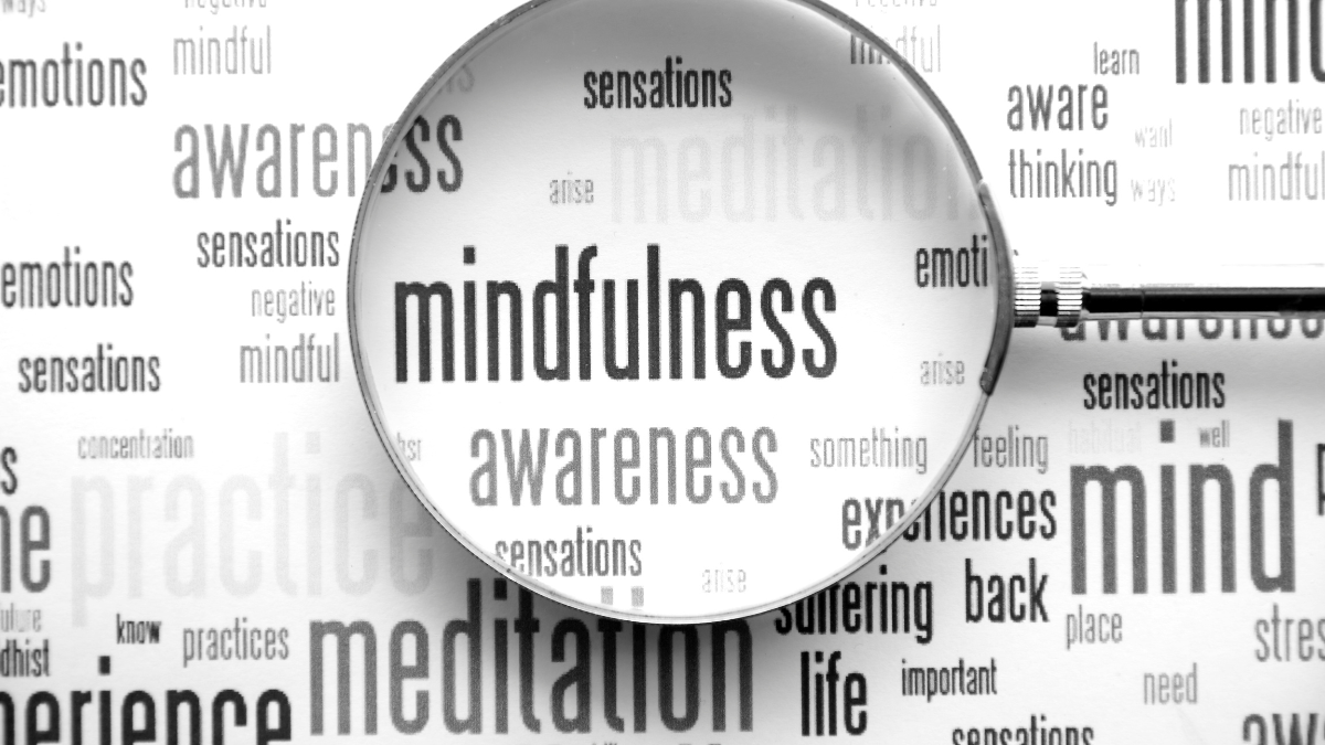 many small words, magnifying glass focused on the words mindfulness awareness