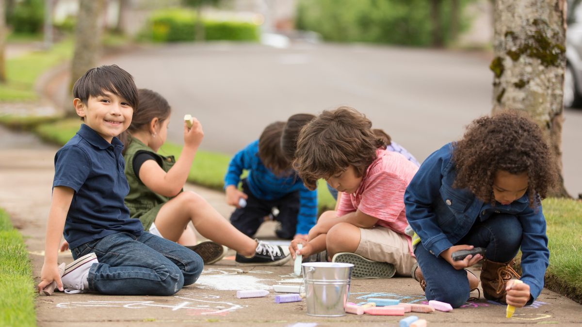 Kids drawing on a sidewalk with sidewalk chalk