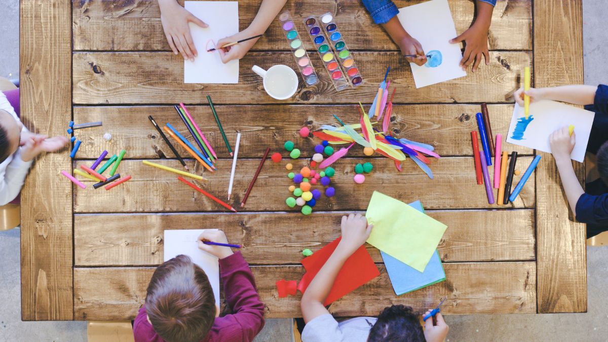 Children work on various crafts around a table
