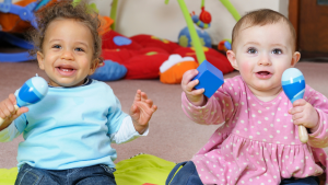 two babies playing with maracas 