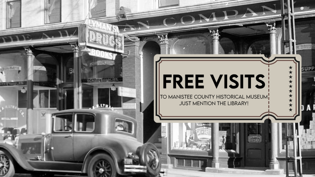black and white photo of downtown manistee. ticket stub reading "free visits"