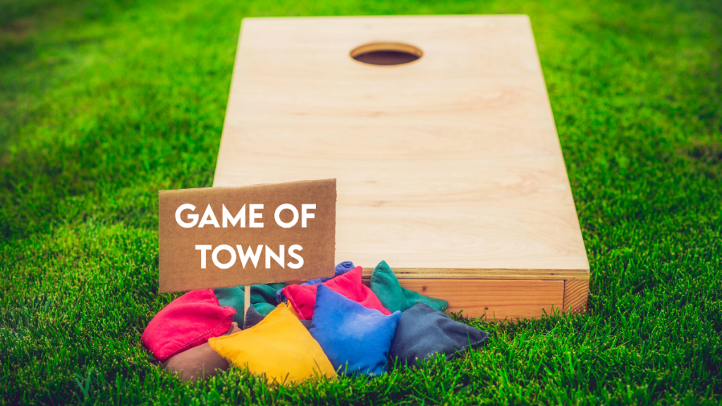 cornhole board and bags, sign reads "Game of Towns"