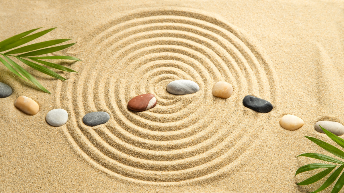 spiral design in sand, strategically placed rocks and leaves