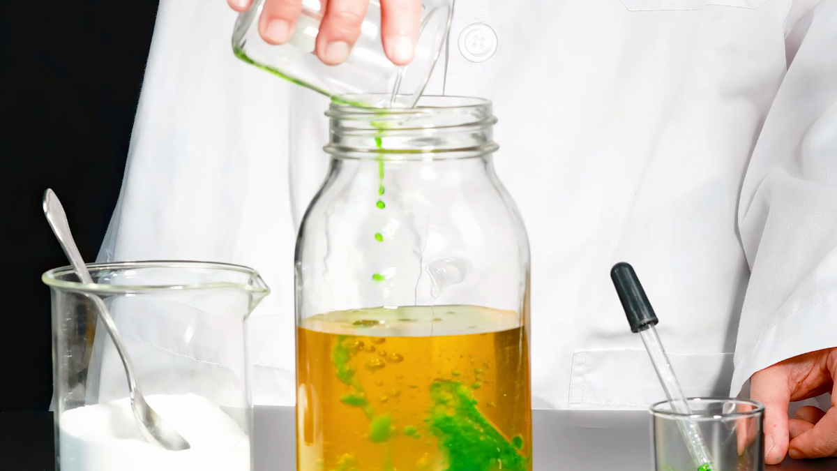 person in lab coat concocting experiment